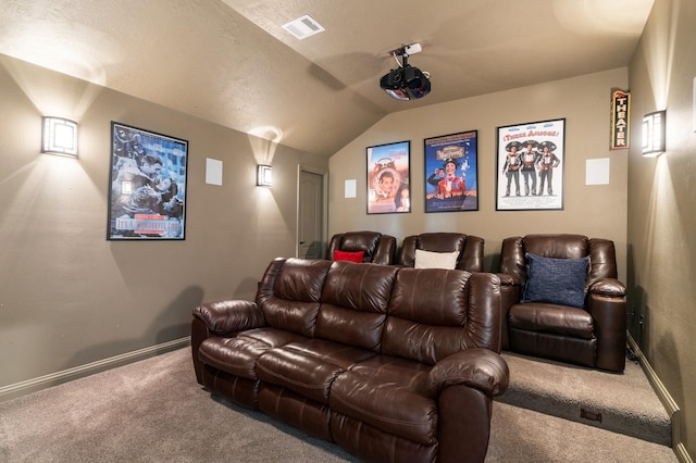 carpeted cinema room with visible vents, baseboards, and vaulted ceiling