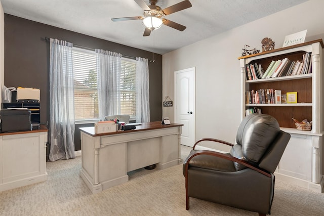 office area with baseboards, light carpet, a textured ceiling, and a ceiling fan