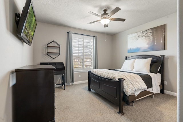 bedroom with light carpet, ceiling fan, a textured ceiling, and baseboards