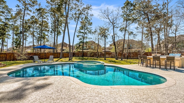 view of pool featuring outdoor dry bar, a patio area, a lawn, and a fenced backyard