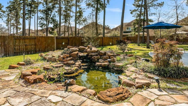 view of yard with a small pond and a fenced backyard