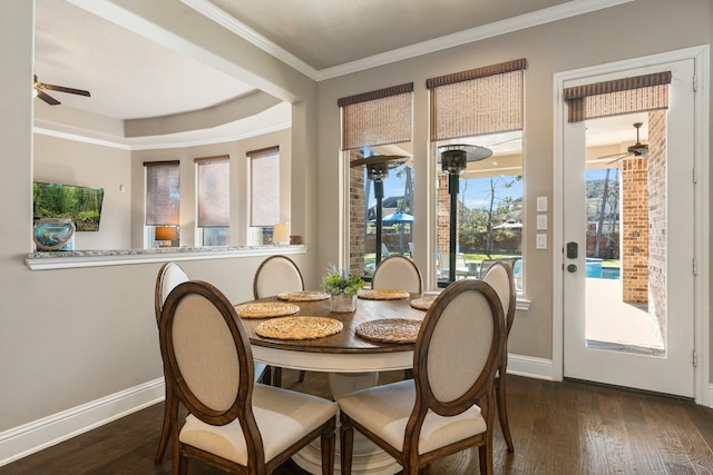 dining room featuring dark wood finished floors, crown molding, and baseboards