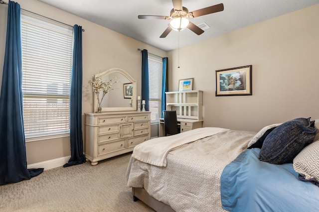 bedroom with visible vents, baseboards, light colored carpet, and a ceiling fan