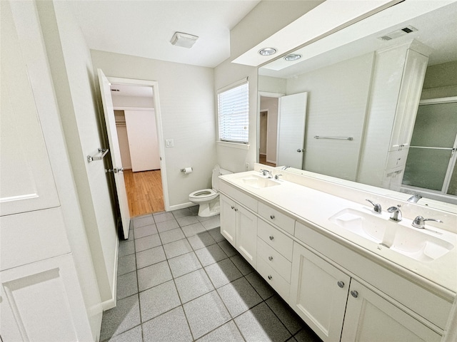 full bathroom with a sink, visible vents, toilet, and double vanity