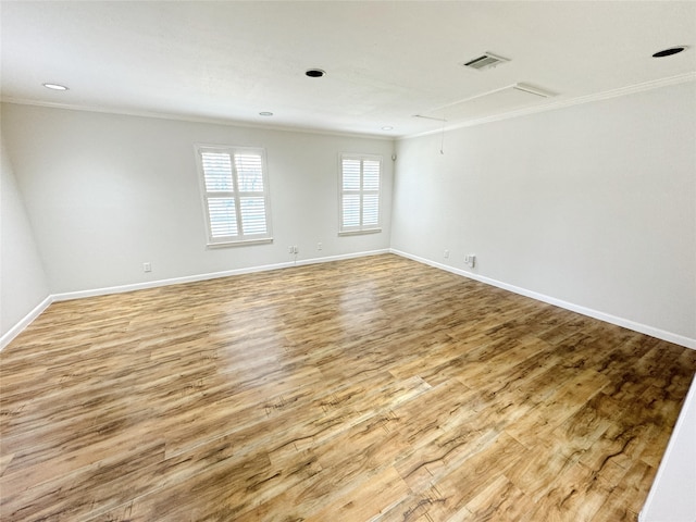 spare room featuring visible vents, attic access, and crown molding