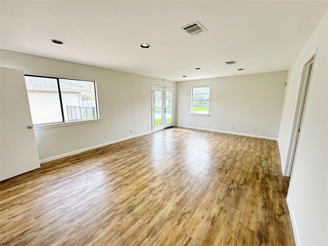 spare room featuring baseboards, french doors, visible vents, and light wood-type flooring