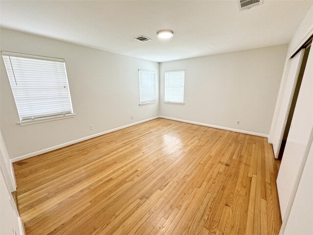 unfurnished bedroom with visible vents, baseboards, and light wood-style floors