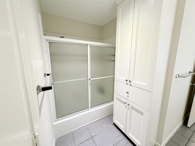 full bath with baseboards and shower / bath combination with glass door