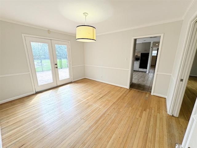 empty room featuring french doors, baseboards, crown molding, and light wood finished floors