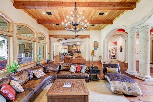 living area with beam ceiling, arched walkways, an inviting chandelier, wooden ceiling, and ornate columns