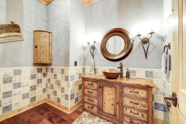 bathroom with vanity, tile walls, wood finished floors, and a wainscoted wall