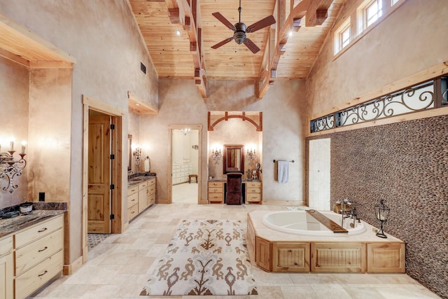 full bathroom with wooden ceiling, beamed ceiling, a garden tub, and a towering ceiling