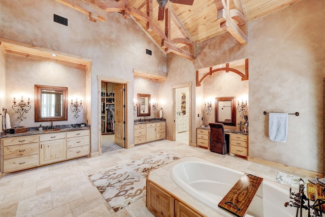 bathroom with visible vents, beam ceiling, a garden tub, two vanities, and wooden ceiling