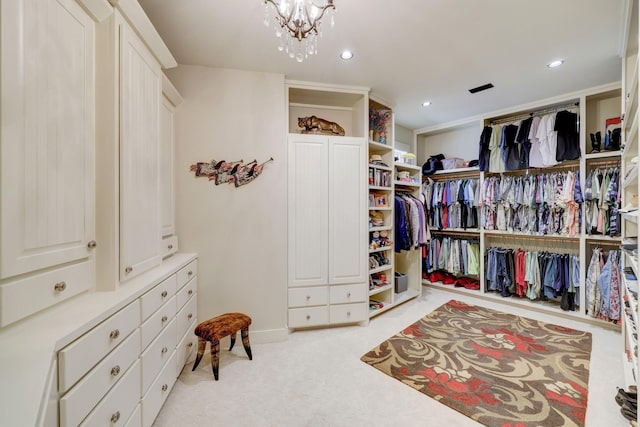 spacious closet featuring a chandelier and light carpet