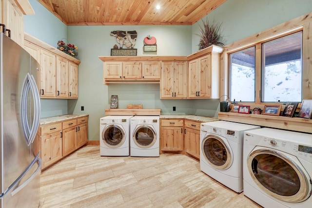 washroom featuring cabinet space, wood ceiling, and washing machine and dryer