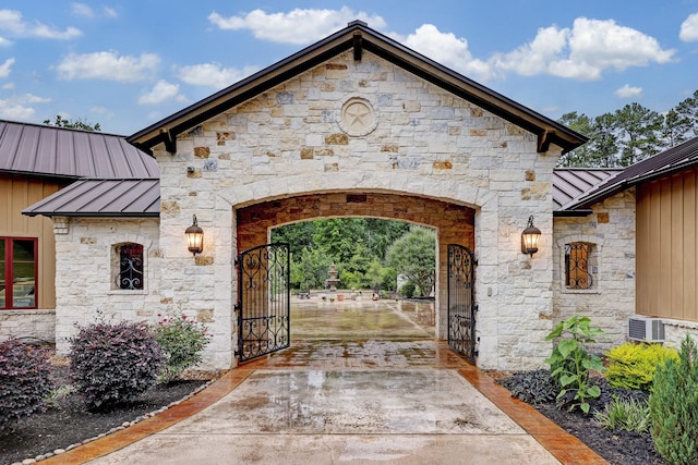 property entrance with a gate, metal roof, board and batten siding, and a standing seam roof