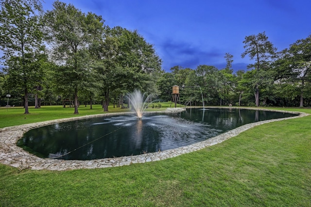 view of property's community featuring a yard and a water view