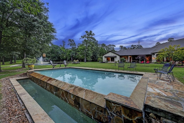 view of pool featuring a lawn