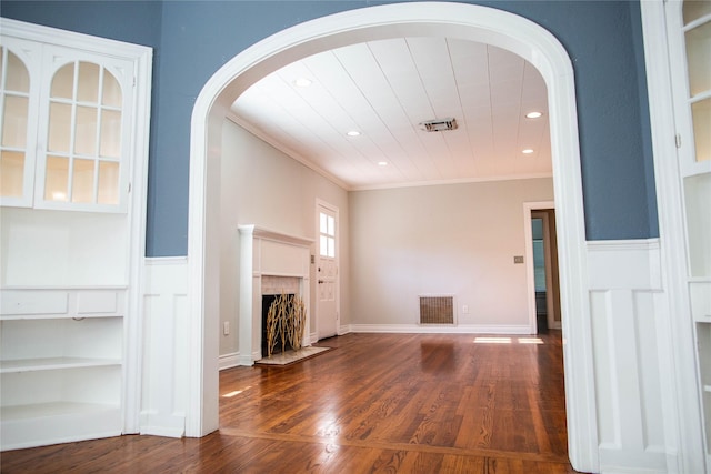 unfurnished living room featuring wood finished floors, visible vents, recessed lighting, a fireplace, and crown molding