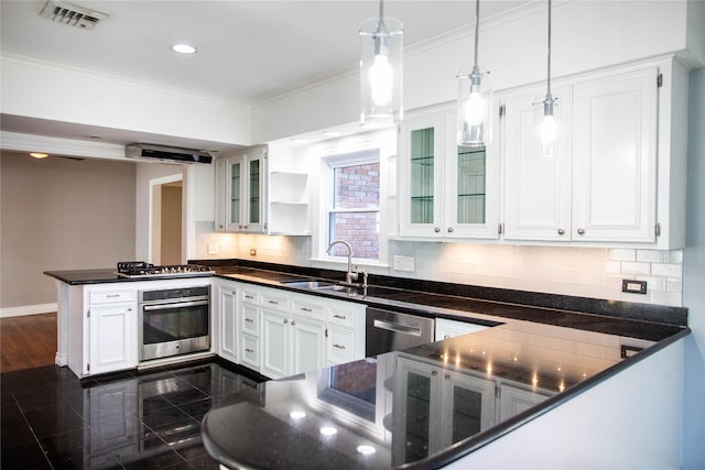 kitchen with a sink, dark countertops, granite finish floor, appliances with stainless steel finishes, and a peninsula