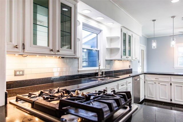 kitchen featuring crown molding, decorative backsplash, hanging light fixtures, white cabinets, and a sink