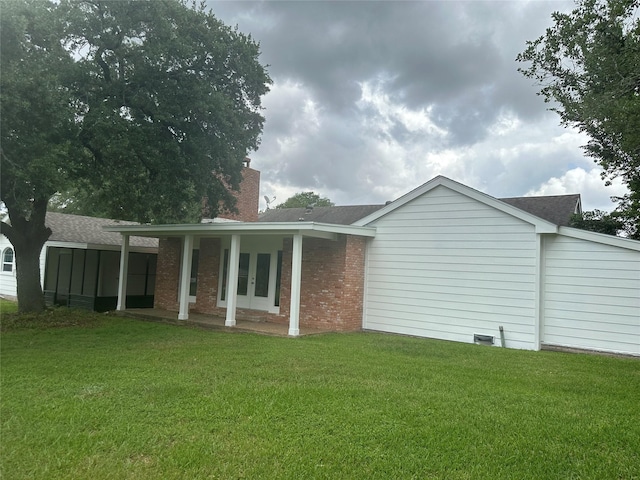 603 S Mccarty Ave, Eagle Lake, TX 77434 - rear view of property with a chimney, french doors, a yard, and brick siding