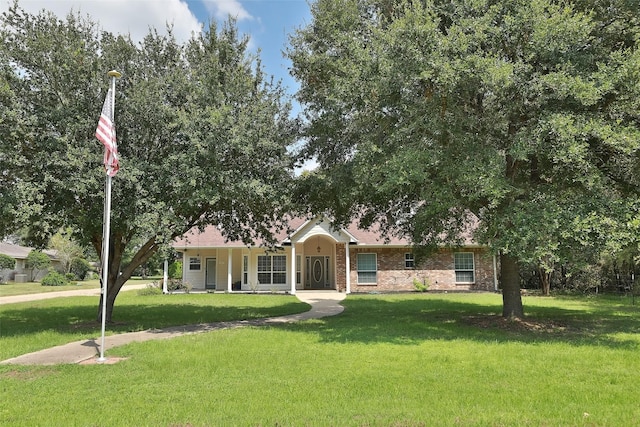 view of front facade with brick siding and a front lawn