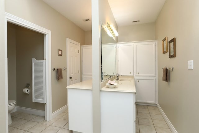 bathroom featuring vanity, baseboards, visible vents, tile patterned flooring, and toilet