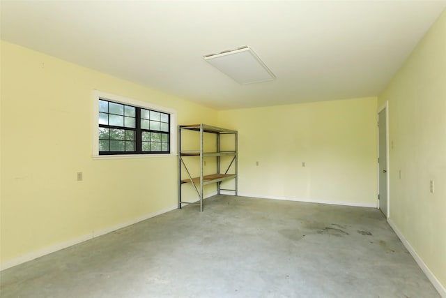 unfurnished room featuring concrete flooring and baseboards