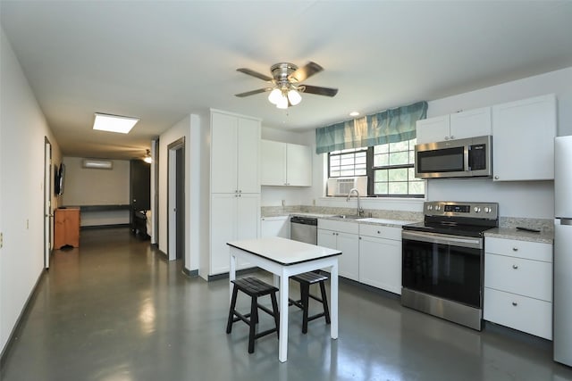 kitchen featuring white cabinets, concrete floors, appliances with stainless steel finishes, and a sink