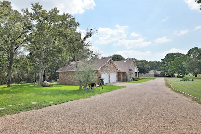 exterior space featuring brick siding, a front lawn, an attached garage, and driveway