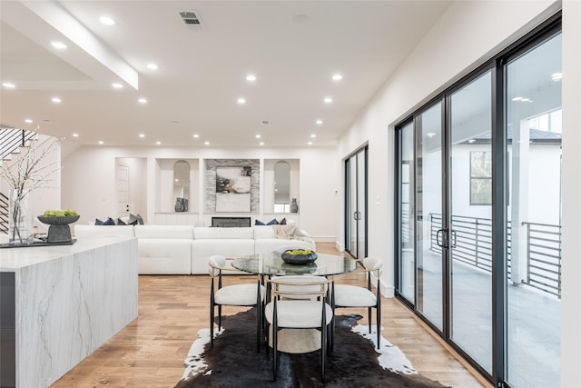 dining space with recessed lighting, visible vents, light wood-style flooring, and stairway