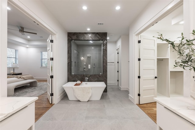 full bathroom featuring a walk in shower, ceiling fan, a freestanding bath, recessed lighting, and wood finished floors