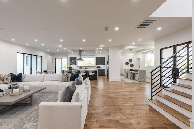 living area featuring recessed lighting, visible vents, and light wood finished floors