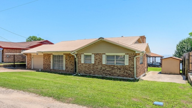 ranch-style home featuring brick siding, a garage, a front lawn, and driveway