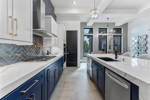 kitchen with a sink, stainless steel appliances, blue cabinets, wall chimney exhaust hood, and tasteful backsplash