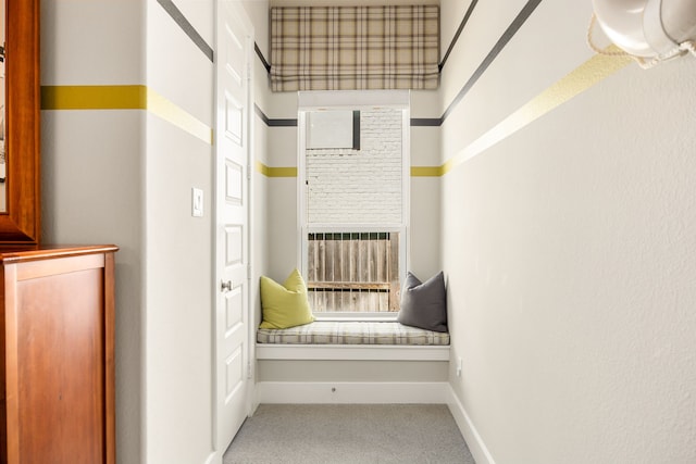 hallway with baseboards and carpet