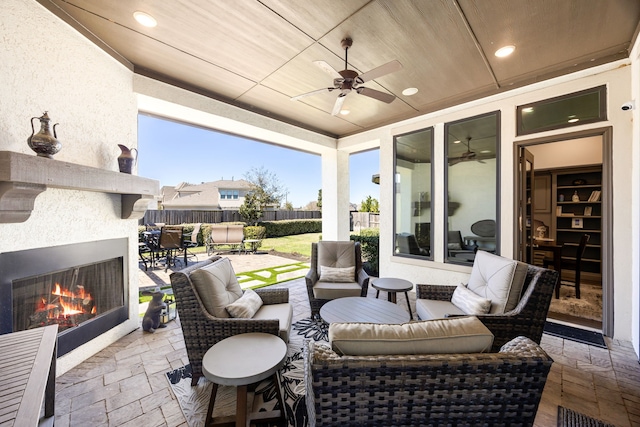 view of patio / terrace featuring an outdoor living space with a fireplace, outdoor dining area, ceiling fan, and fence