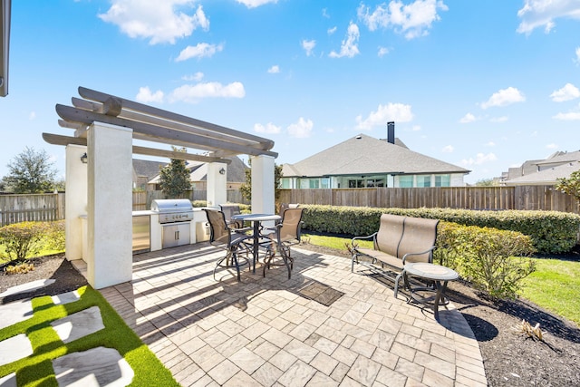 view of patio / terrace with grilling area, exterior kitchen, outdoor dining area, a fenced backyard, and a pergola