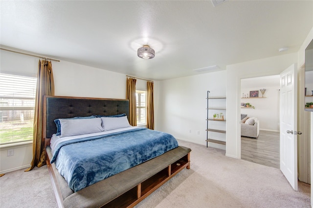 bedroom with baseboards and light carpet