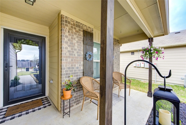 doorway to property with brick siding and covered porch