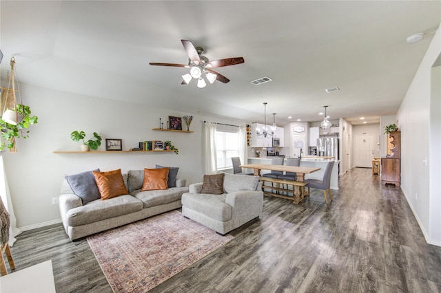 living room featuring visible vents, dark wood-type flooring, baseboards, recessed lighting, and ceiling fan with notable chandelier