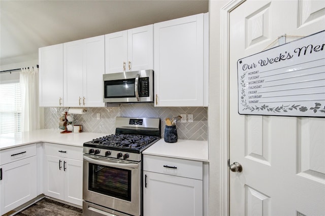 kitchen with backsplash, appliances with stainless steel finishes, and white cabinets