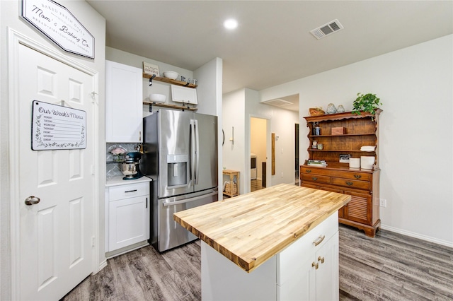 kitchen with visible vents, open shelves, wood counters, white cabinetry, and stainless steel fridge