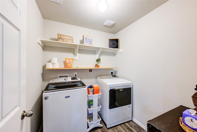 washroom with laundry area, wood finished floors, separate washer and dryer, and baseboards