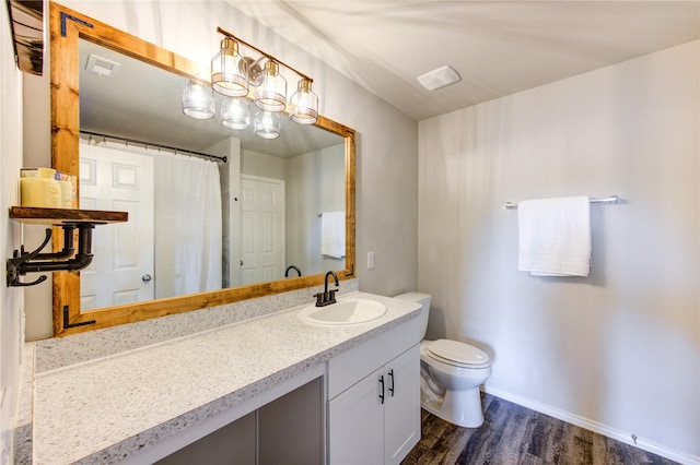 bathroom with visible vents, baseboards, toilet, wood finished floors, and vanity