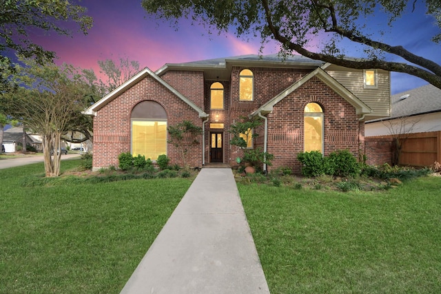 traditional-style house featuring brick siding and a front yard