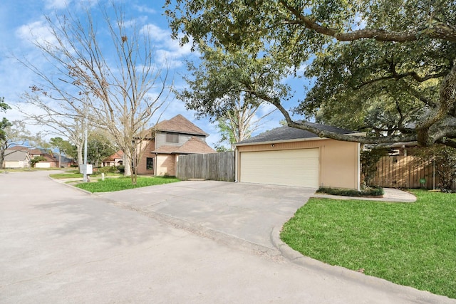 view of front of house with driveway, a front yard, and fence