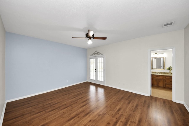 unfurnished bedroom featuring visible vents, baseboards, dark wood finished floors, french doors, and a textured ceiling