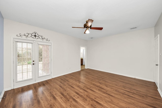 empty room featuring visible vents, baseboards, a ceiling fan, and wood finished floors